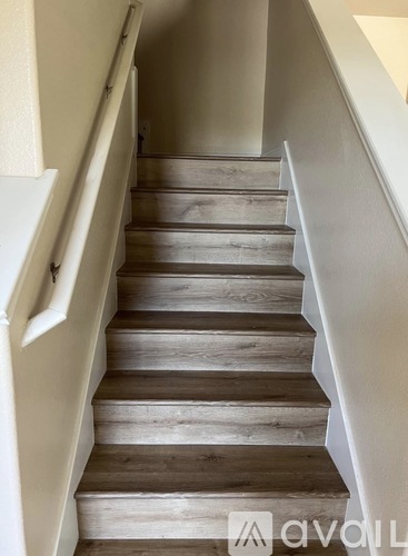 A set of stairs with wooden steps and white railings.