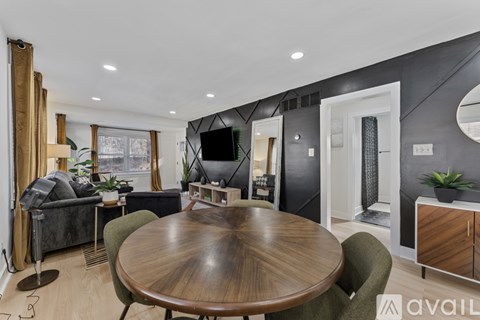A modern living room with a wooden table and grey chairs.