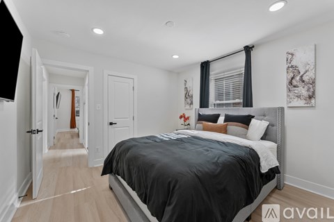 A bedroom with a large bed and a painting on the wall.