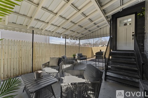 A patio with a table and chairs under a roof.