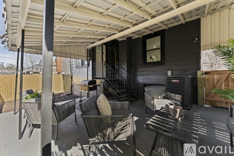 A patio with a black couch and a white pillow.