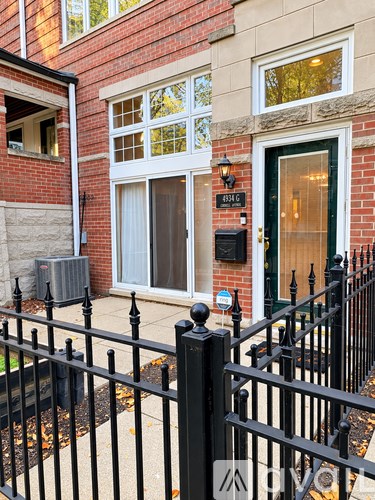 A black iron fence in front of a brick house.