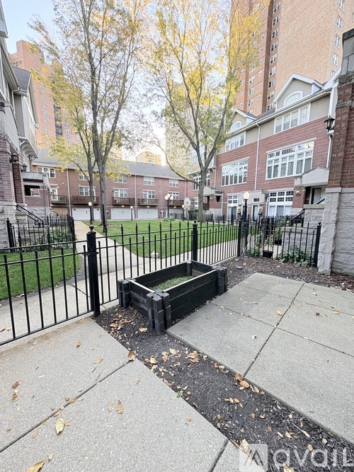 A black fence surrounds a small garden area.