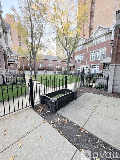 A black fence surrounds a small garden area.