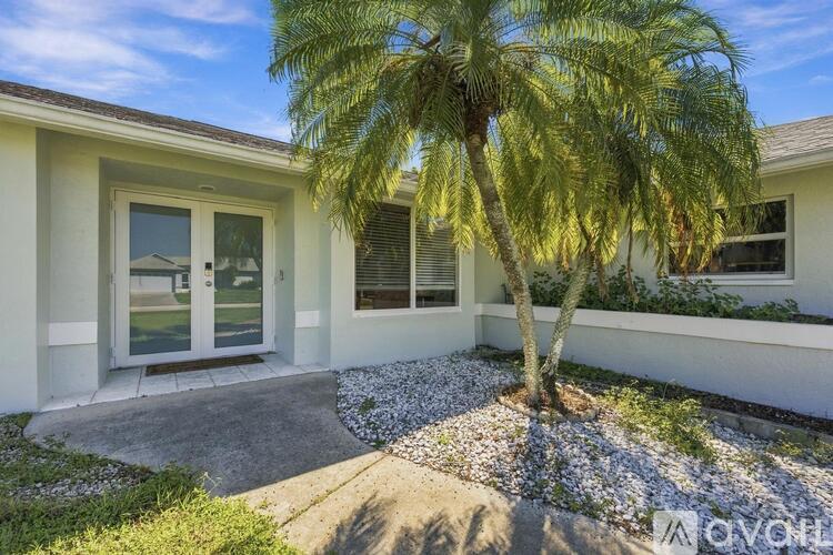 A house with a palm tree in front of it.