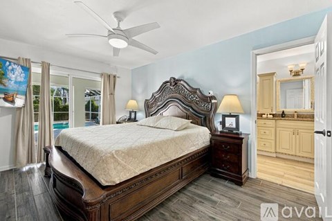 A bedroom with a large bed and a ceiling fan.