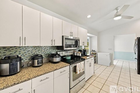 A kitchen with white cabinets and a granite countertop.