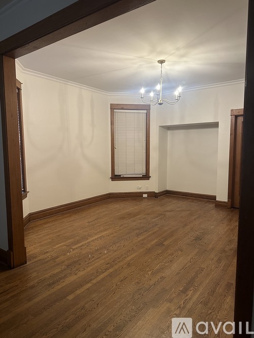 A room with wooden floors and a chandelier.