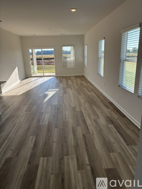 A room with wooden flooring and a large window.