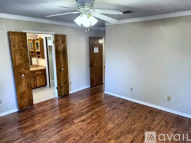 A room with wooden floors and a ceiling fan.