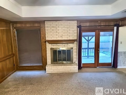A living room with a fireplace and a sliding glass door.
