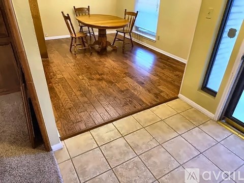 A dining room with a wooden table and chairs.