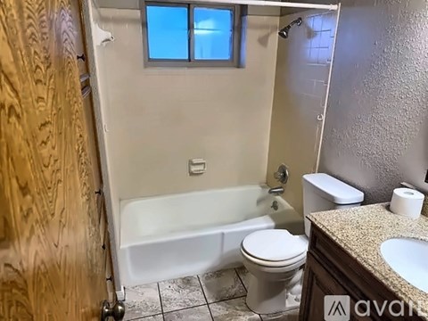 A bathroom with a toilet, sink, and bathtub.