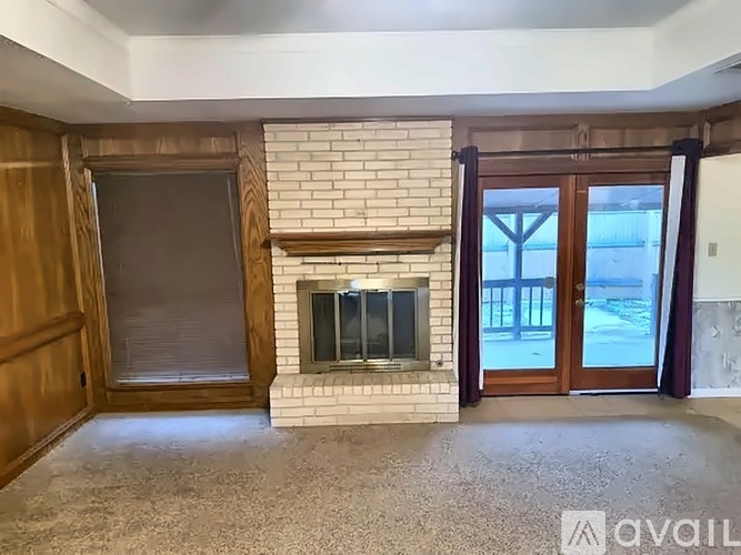 A living room with a fireplace and a sliding glass door.