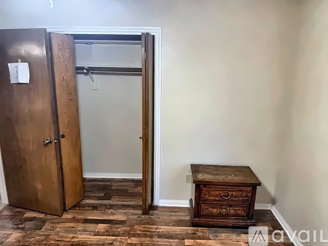 A wooden door with a number 3 on it is open to a room with a wooden table.