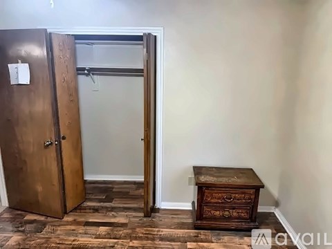 A wooden door with a number 3 on it is open to a room with a wooden table.