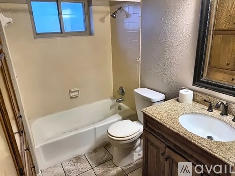 A bathroom with a white bathtub, toilet, and sink.