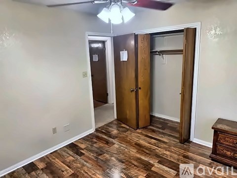 A room with a wooden floor and a ceiling fan.