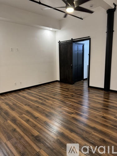 A room with wooden flooring and a ceiling fan.