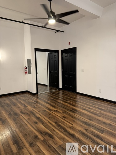 A room with wooden floors and a ceiling fan.