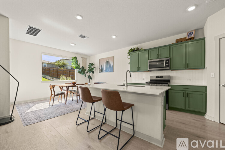 A kitchen with green cabinets and a white countertop.