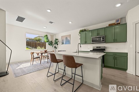 A kitchen with green cabinets and a white countertop.