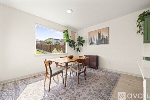 A dining room with a table and chairs.