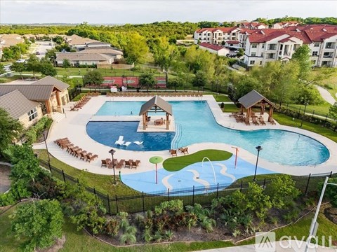 A large swimming pool surrounded by a black fence and a gazebo.