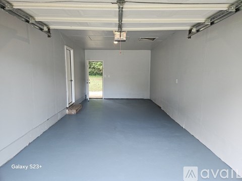 A spacious garage with a door on the left and a window on the right.