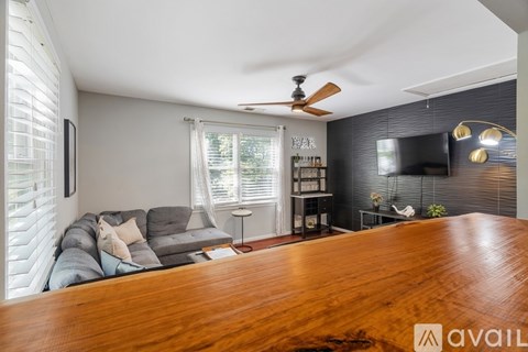 A living room with a grey couch and a wooden table.