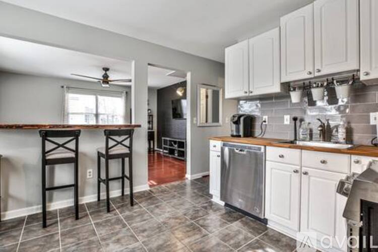 A kitchen with white cabinets and a tile floor.