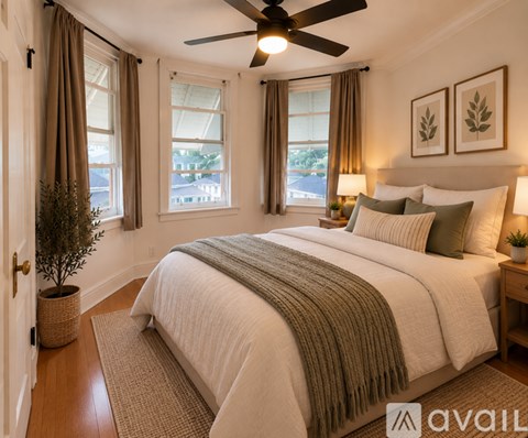 A bedroom with a large bed and a ceiling fan.