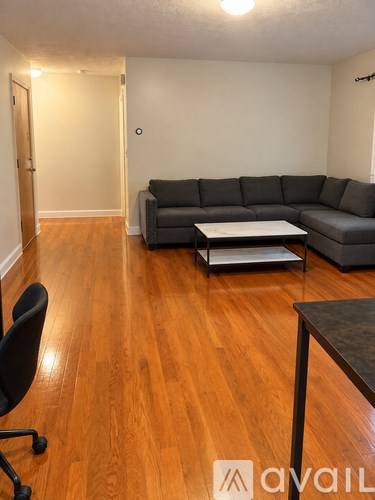 A living room with a grey couch and a black chair.