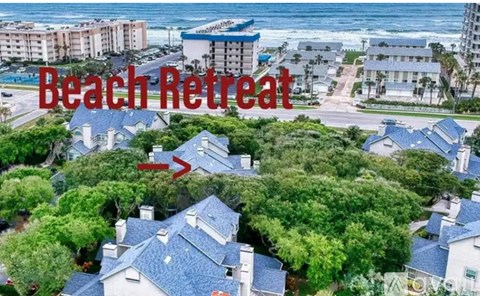 A beachfront property with a red arrow pointing to a house.