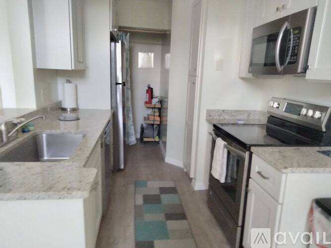 A kitchen with white cabinets and a stainless steel refrigerator.