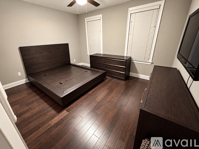 A bedroom with a large bed and a television on the wall.