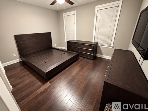 A bedroom with a large bed and a television on the wall.