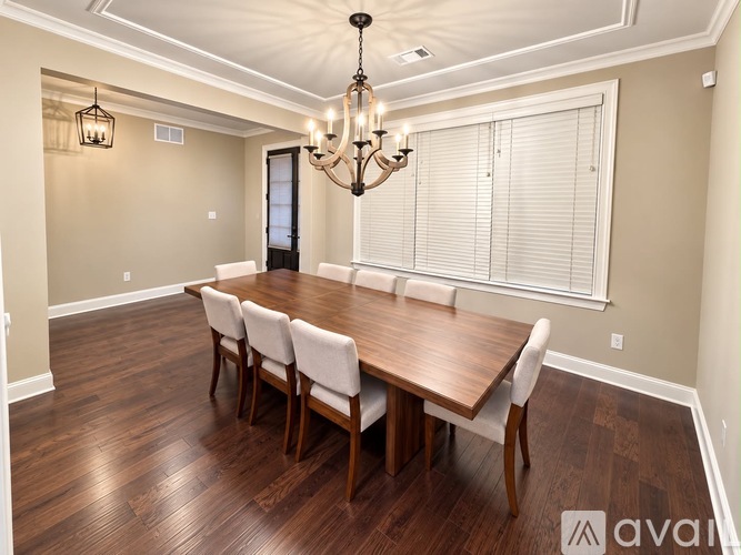 A dining room with a wooden table and chairs.
