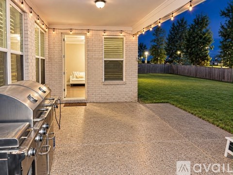 A patio with a BBQ grill and lights.