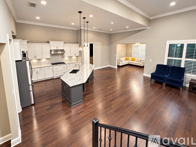 A spacious kitchen with a dining area and a living room with a sofa.