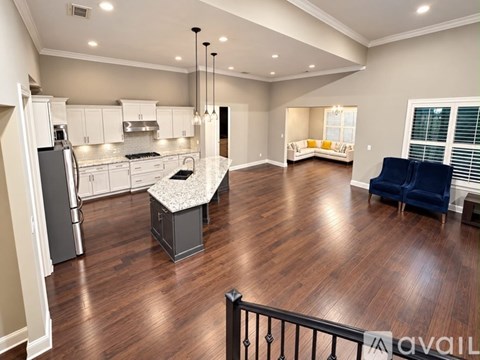 A spacious kitchen with a dining area and a living room with a sofa.