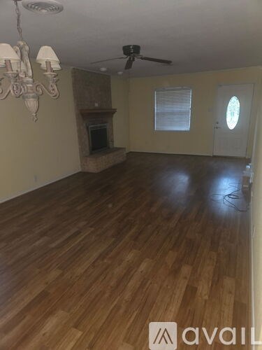 A room with wooden flooring and a chandelier.