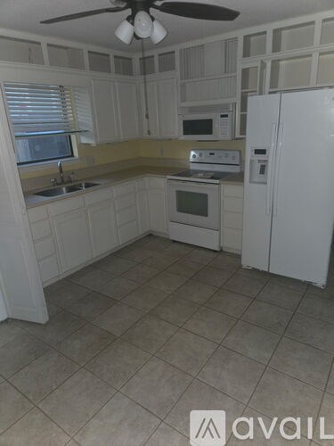 A kitchen with white cabinets and appliances.