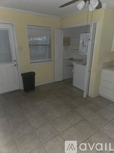 A kitchen with a white refrigerator and a black trash can.