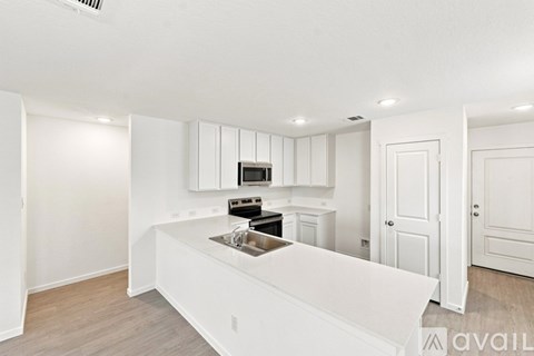 A kitchen with white cabinets and a white island.