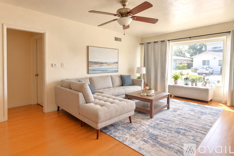 A living room with a white couch and a ceiling fan.