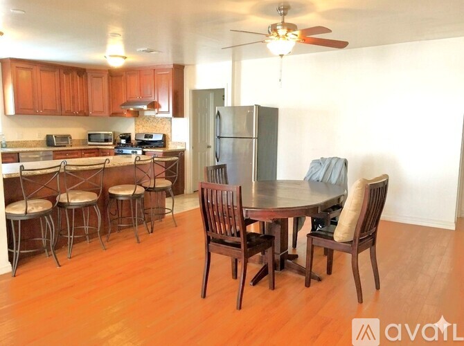 A kitchen with wooden cabinets and a dining table with chairs.