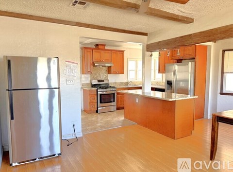 A kitchen with wooden cabinets and a refrigerator.