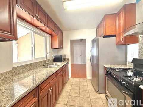 A kitchen with brown cabinets and a granite countertop.