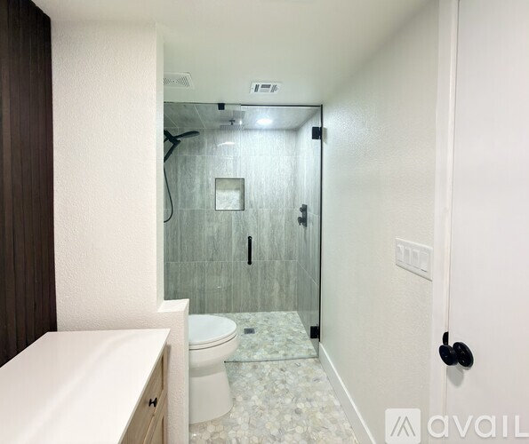 A bathroom with a toilet, sink, and walk-in shower.